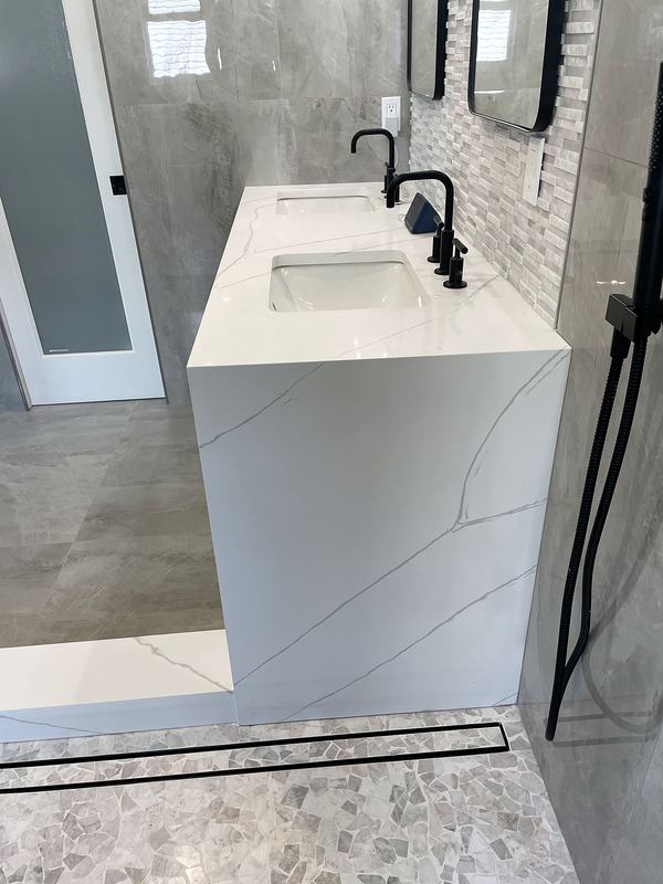 Bathroom remodel with waterfall quartz vanity and matte black fixtures