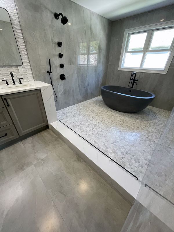 Spa bathroom with freestanding soaking tub and large-format porcelain walls