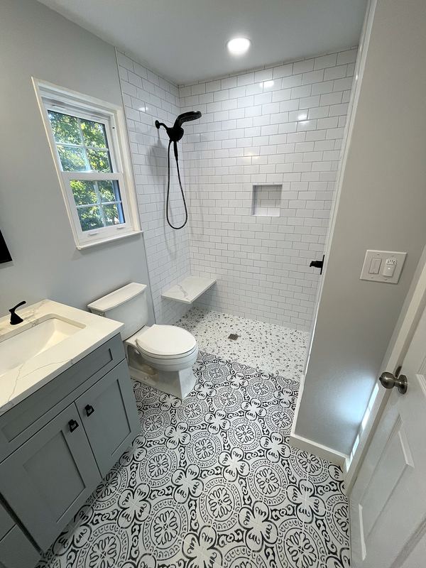 Subway tile shower with bench and patterned floor