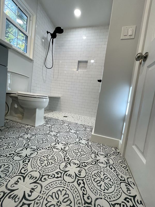 Patterned floor tile with walk-in subway tile shower