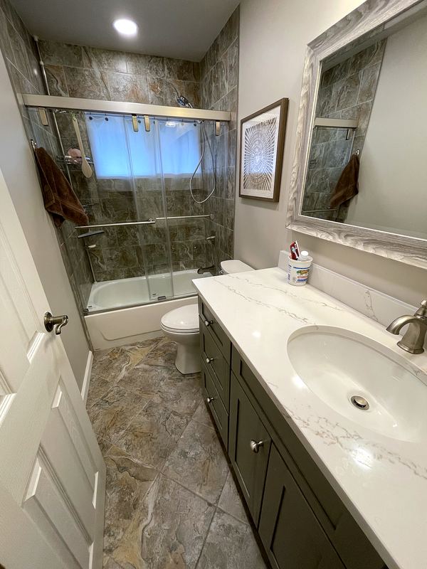 Gray vanity with tub and sliding glass doors