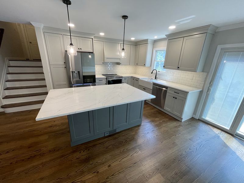 Kitchen remodel with gray island, white quartz and pendant lights