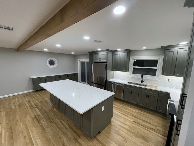 Gray shaker kitchen with quartz island and beamed ceiling
