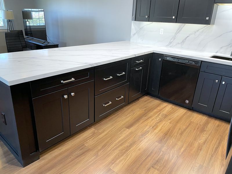 Kitchen with black cabinets and white marble-look quartz