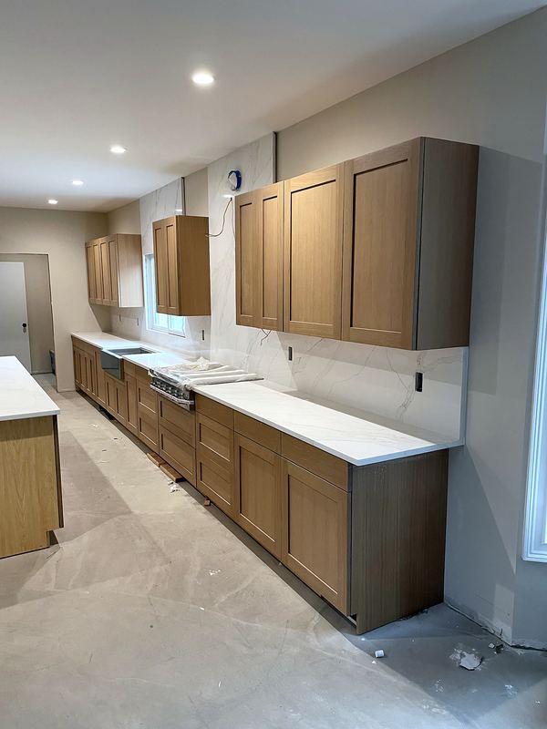 Kitchen with wood-tone shaker cabinets and white quartz