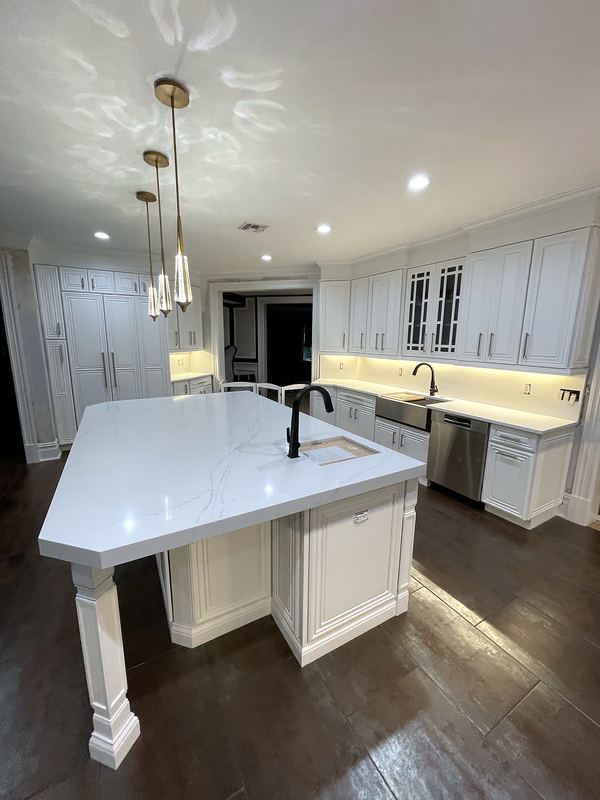 White kitchen with quartz island and pendant lights