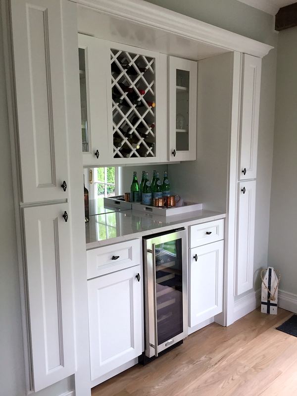 White built-in bar with wine rack and beverage fridge