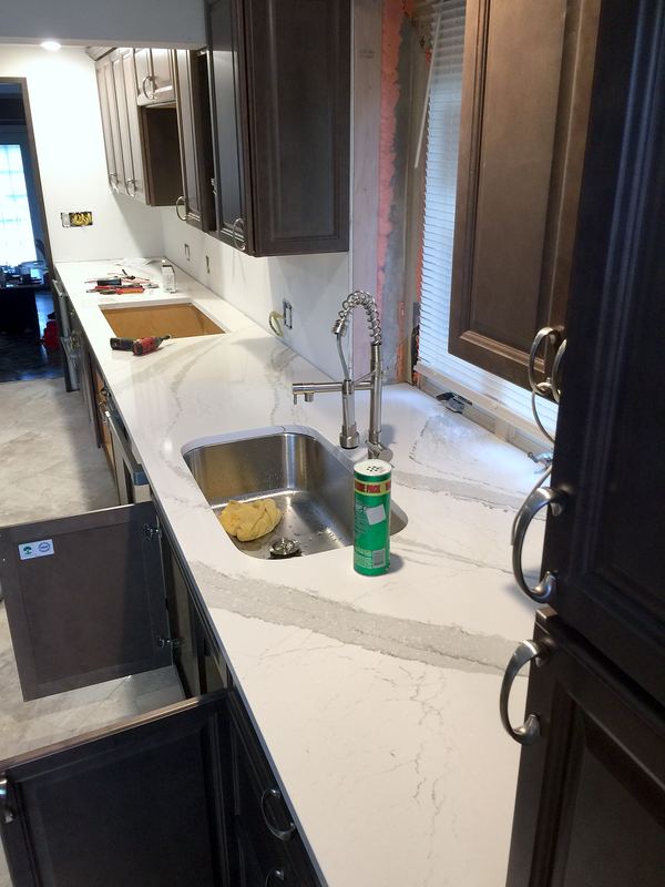 White quartz countertop with undermount sink and dark cabinets