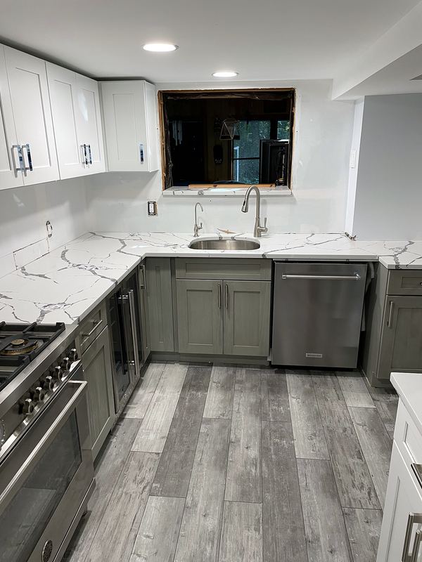 Gray and white kitchen with Calacatta-look quartz and plank floors