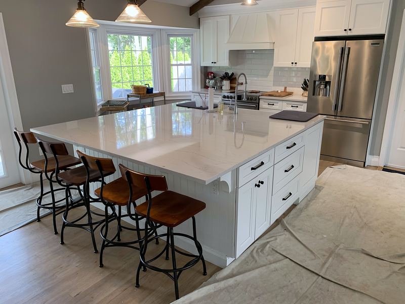 Large white island with quartz top and seating for five