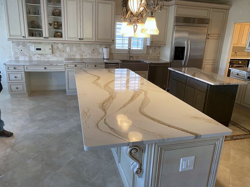Kitchen island with dramatic veined quartz and gray base