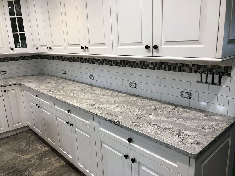 White kitchen with gray granite and mosaic accent backsplash